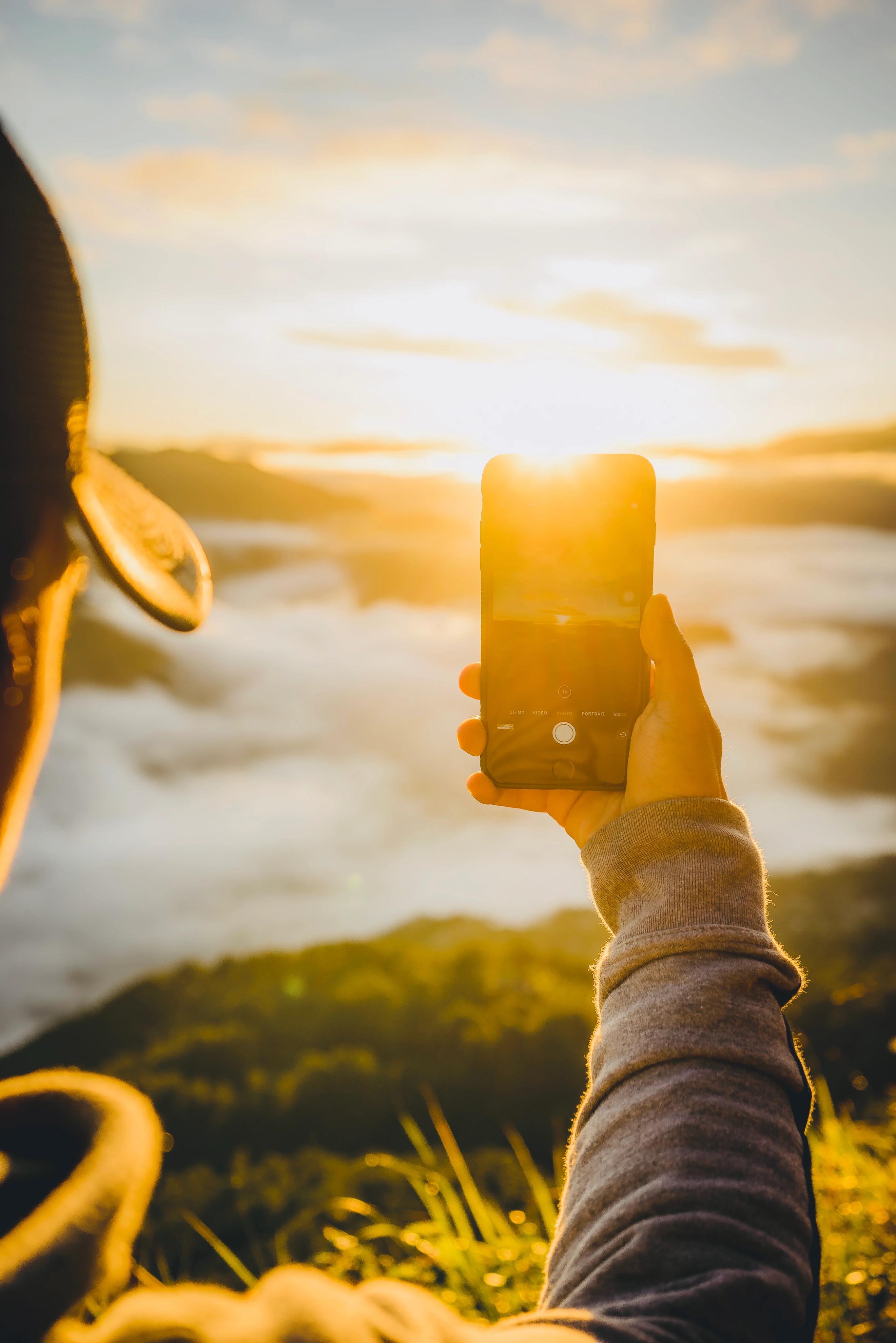 Een persoon kijkt op een telefoon in direct zonlicht